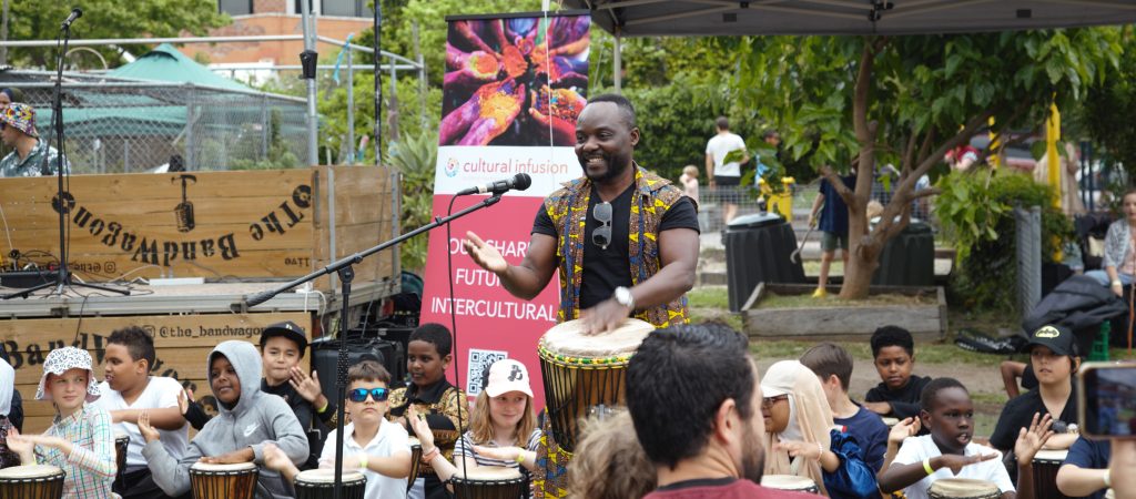 Presenter playing a Djembe with young student also playing the djembe