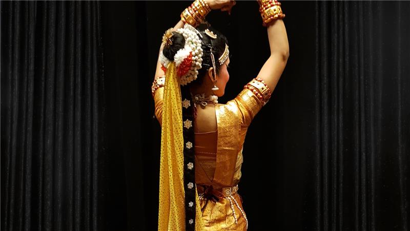 A woman in traditional Indian attire doing a Bollywood dance pose. 