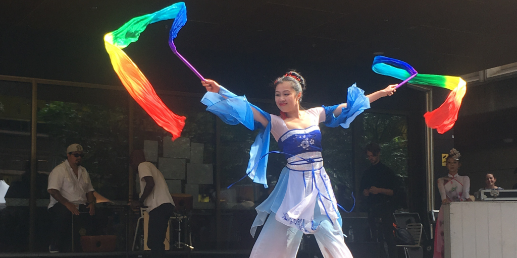 Celebrating Lunar New Year in the Classroom - the picture is of Cultural Infusion's Chinese Classical Dance presenter in traditional blue attire, holding ribbons and mid-Ribbon Dance performance.
