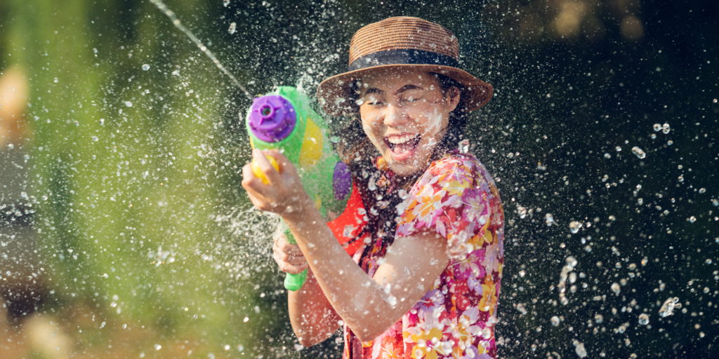 14 April Dates to Celebrate - this is a photo of a woman with a water gun, mid water-fight.