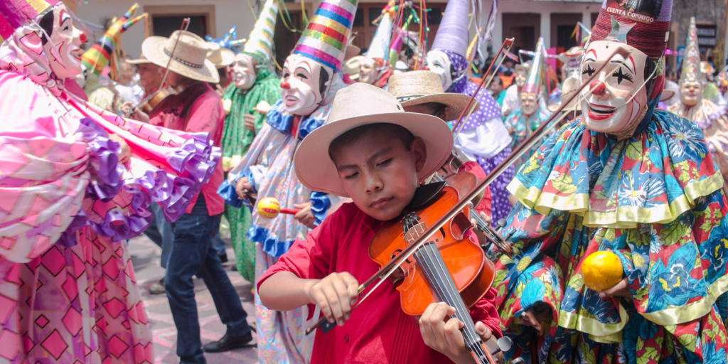 May Cultural Celebrations: Diversity, Education, and Awareness – this photo is of a Cinco De Mayo celebration focusing on a young boy playing the violin.